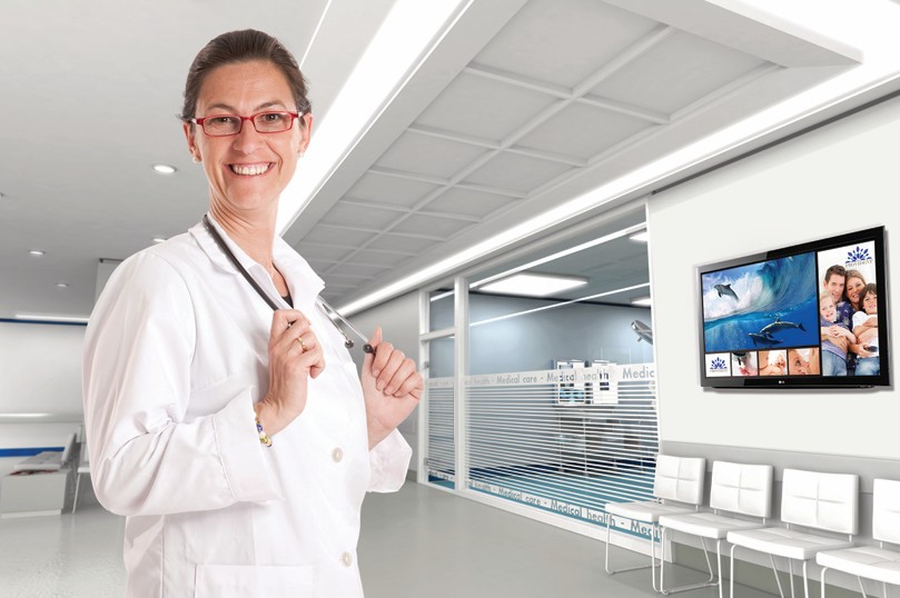 Healthcare room with wall-mounted LG TV showing educational content